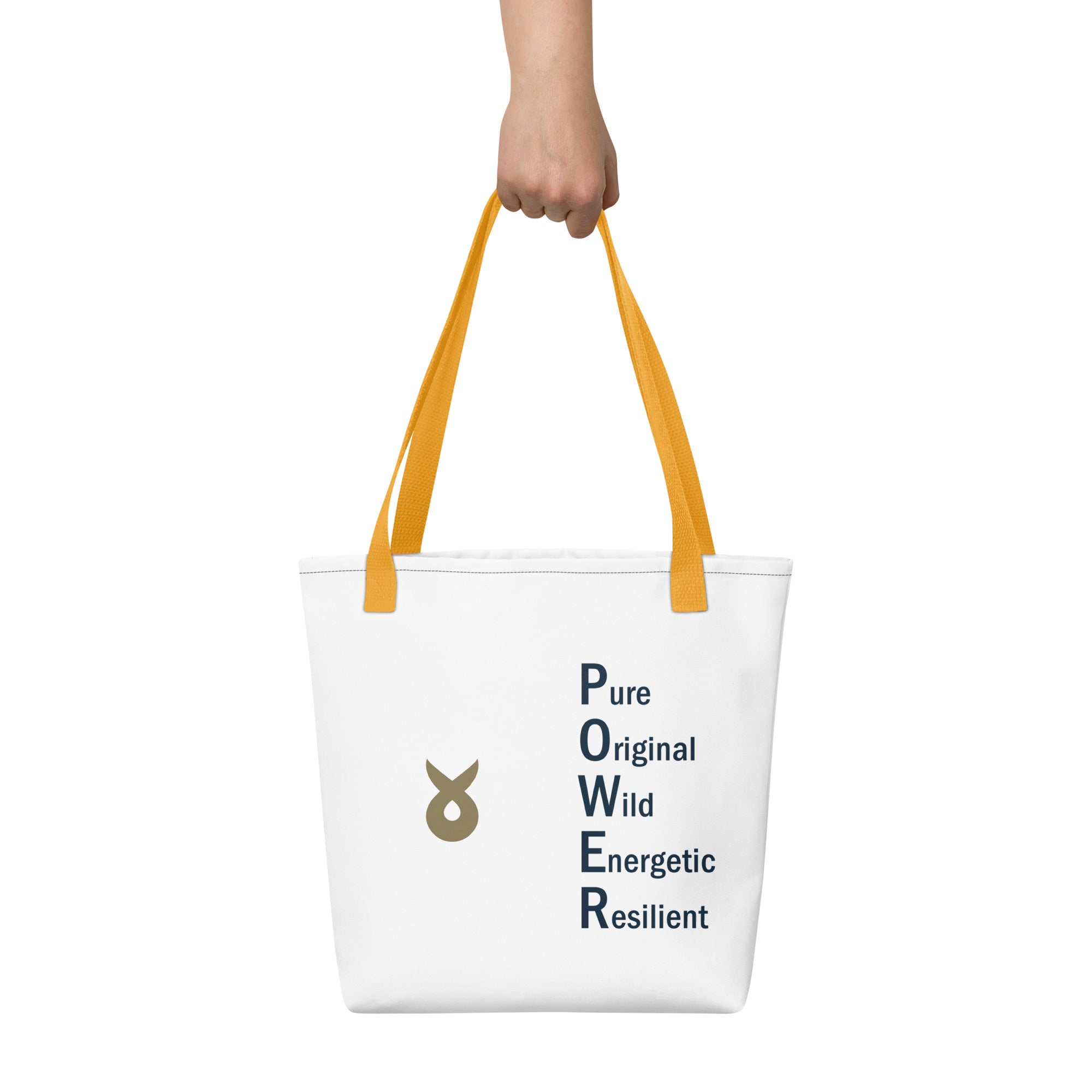 White tote bag with yellow handles, featuring the word "POWER" written vertically as an acronym (Pure, Original, Wild, Energetic, Resilient) and a gold Ballstad logo beside the text, held by a hand against a plain white background.