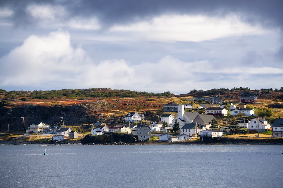  View of a small town on a rocky Atlantic Ocean Coast during a cloudy day. Taken in Twillingate, Newfoundland, Canada.