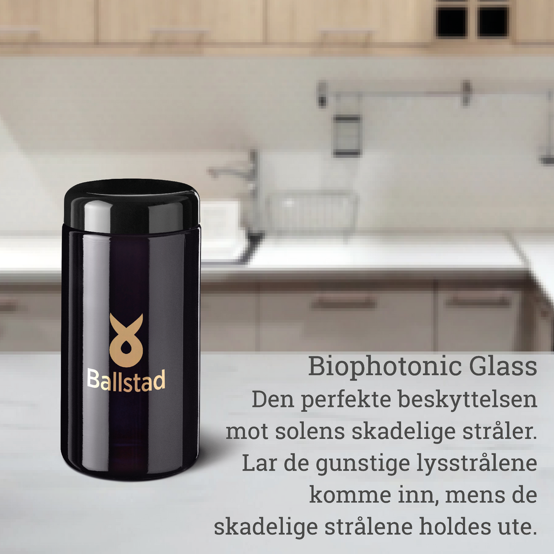A sleek black Ballstad biophotonic glass jar is placed on a kitchen counter. Norwegian text beside it describes the jar as the perfect protection against harmful sunlight, allowing beneficial light rays in while blocking damaging ones. The setting features a modern kitchen background.